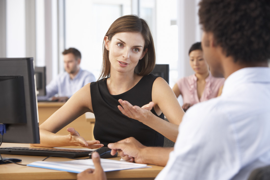 Two Business People Having Meeting In Busy Office